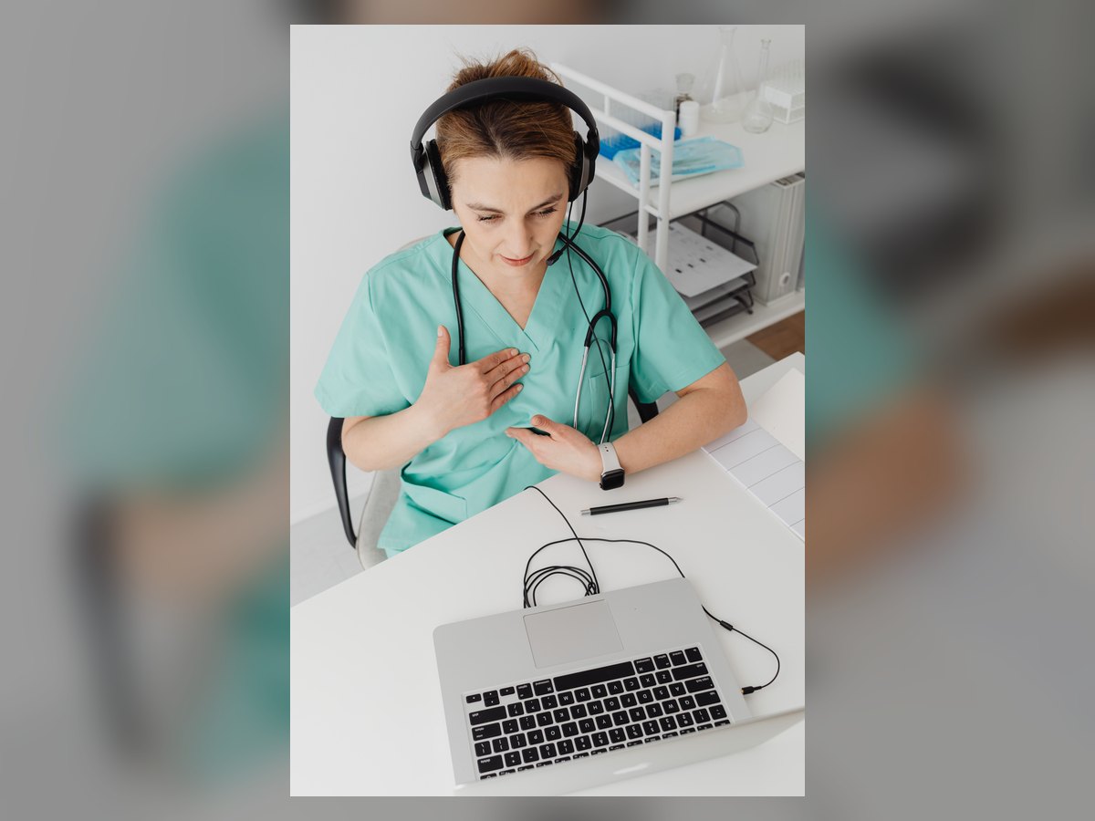 Profissional de saúde realizando atendimento por vídeo em um computador