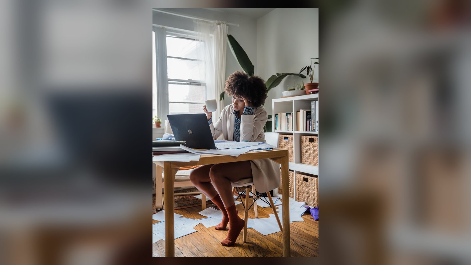 Profissional cansada diante de um computador e documentos de trabalho
