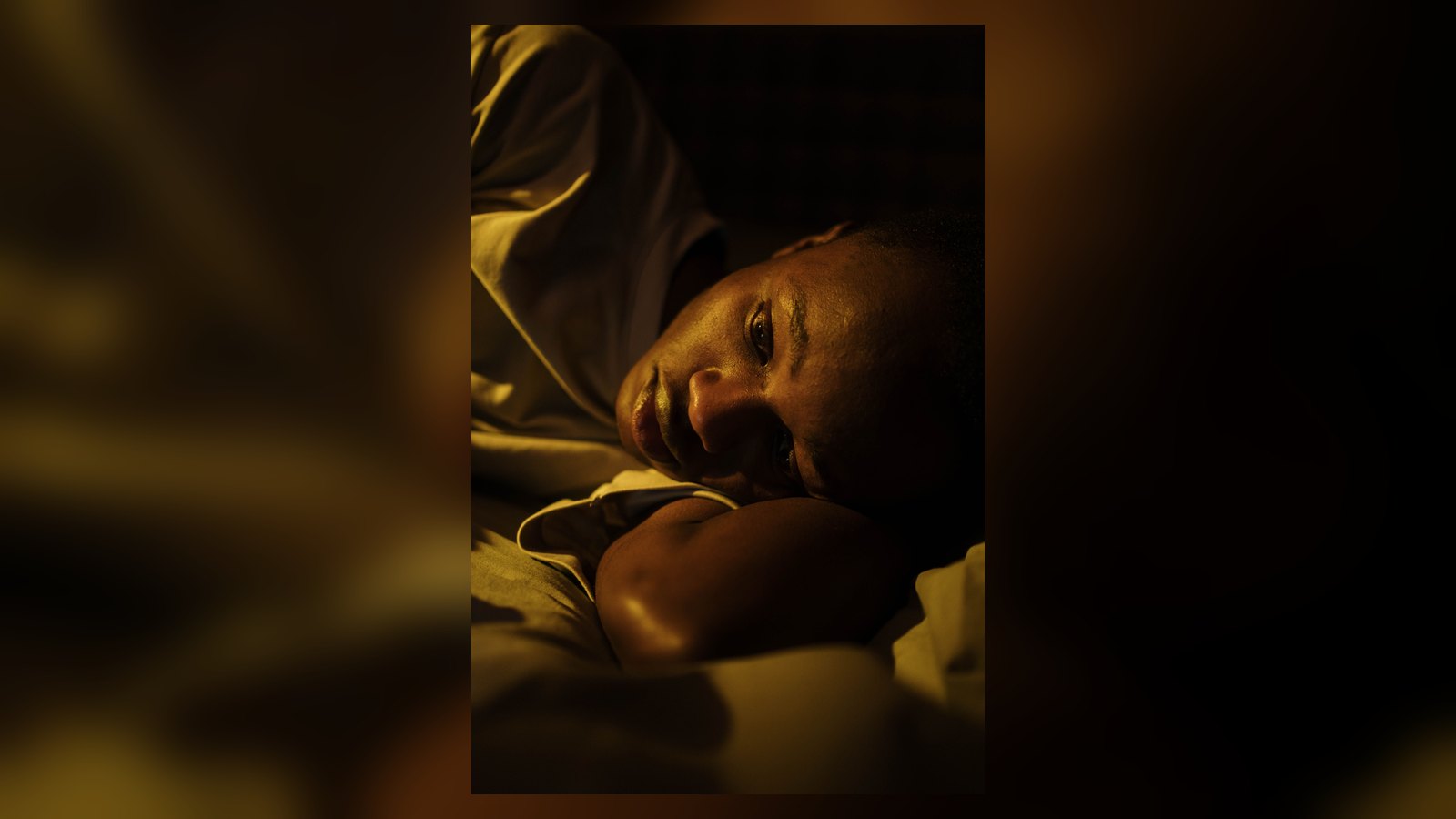 Pessoa acordada na cama durante a noite, representando dificuldade para dormir